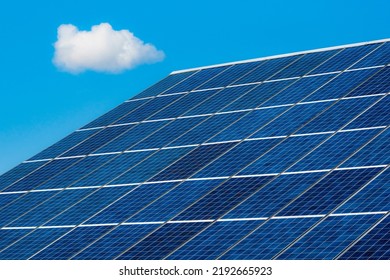 Solar Photovoltaic Panels On The Roof With A Single Cloud In The Sky. Technology For Renewable Energy Solution. Close Up Solar Cell Battery Harness Energy Of The Sun.