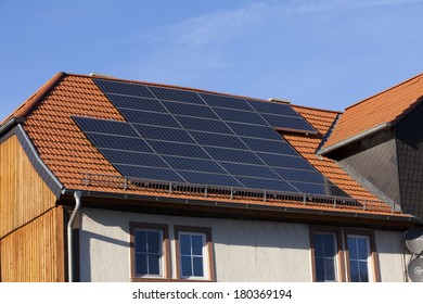 Solar Power Photovoltaic Energy Panels On Tiled House Roof