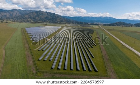 Solar power plant in the Republic of Gorny Altai. Solar panels in a field against the background of mountains. Alternative green energy. Photos of the Republic of Gorny Altai in summer, aerial photo
