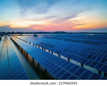 Solar Power Station At Beautiful Sunset. Solar Photovoltaic Power Station On Water. Green Energy Concept.