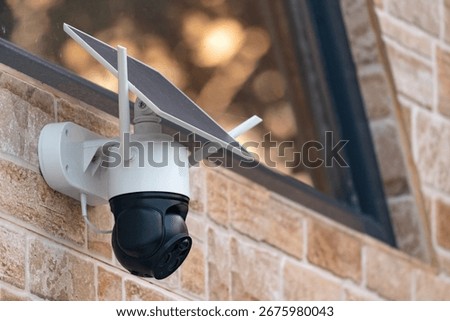 Solar powered wireless security camera on country house wall