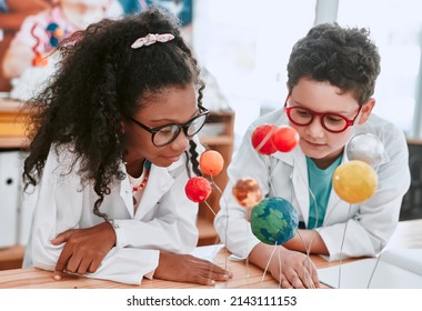 The Solar System Is So Vast And Interesting. Shot Of Two Adorable Young School Pupils Learning About Planets And The Solar System In Science Class At School.