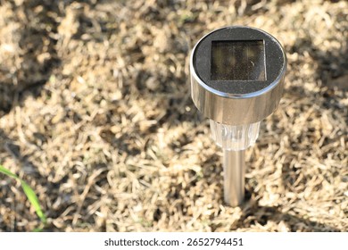 SolarPowered Garden Light Placed Securely on Grass for Outdoor Aesthetics and Illumination