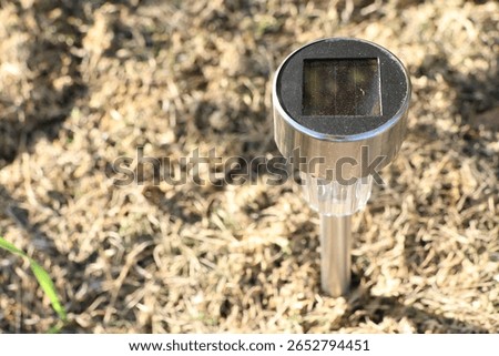 SolarPowered Garden Light Placed Securely on Grass for Outdoor Aesthetics and Illumination