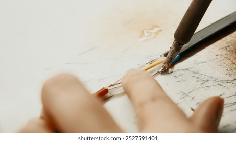 Soldering iron, wiring repair. Creative. Close up of industrial background of worker in protective gloves repairing a wire. - Powered by Shutterstock