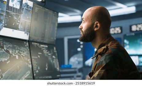 Soldier doing patriotic duty in military HQ base, gathering information on enemy troops. Officer using high tech monitoring gear to do assessment of enemy vulnerabilities, camera A - Powered by Shutterstock