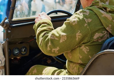 A Soldier Driver Driving An Old Military Vehicle From The Lend-Lease Era. Historical Reconstruction Of The Events Of World War II. Parade On Victory Day May 9. Selective Focus.