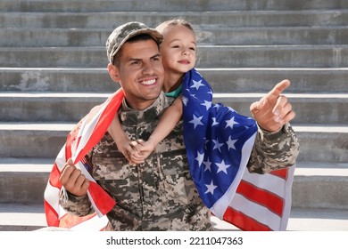 Soldier With Flag Of USA And His Little Daughter Outdoors