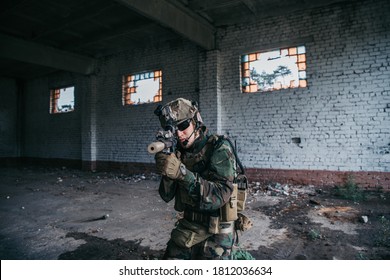 Soldier In Full US MARSOC Armed With Assault Rifle Run Through The Abandoned Building. Military Clash.