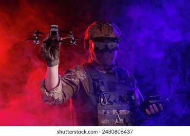 Soldier in gear holds drone against a red and blue smoky background, conveying intensity and military action - Powered by Shutterstock