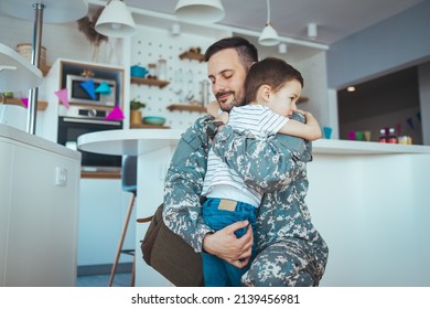 Soldier And His Little Son Hugging At Home. Smiling Soldier Reunited With His Son After Coming Back From War. Military Soldier Father With Son Kid Smiling During Home Return - Family Love US Army