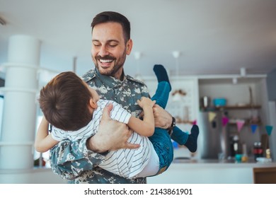 Soldier And His Little Son Hugging At Home. Smiling Soldier Reunited With His Son After Coming Back From War. Military Soldier Father With Son Kid Smiling During Home Return - Family Love US Army