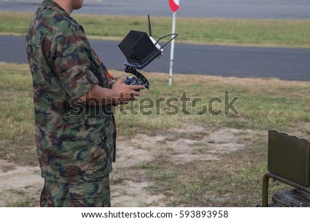 Soldier holding remote controller in hands close-up. Male hands piloting rc car, drone or helicopter. Pilot running his vehicle with transmitter outdoor, free space