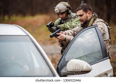 Soldier Points Gun At Suspicious Car Passenger. Anti Terrorism Military 
 Check Point.