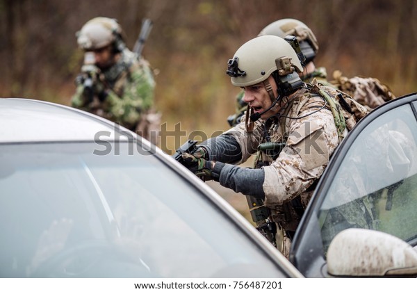 soldier points gun at suspicious car
passenger. anti terrorism military check
point.
