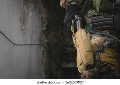 Soldier pulls a pistol from a holster on his belt close up.
