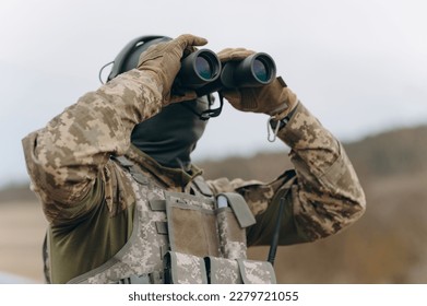 soldier, ranger or hunter with binoculars watching the forest - Powered by Shutterstock