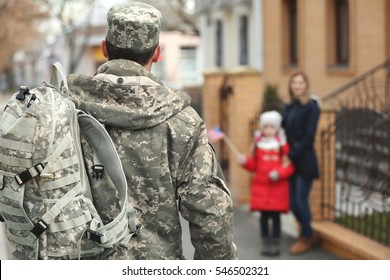 Soldier returning from war with blurred family on background - Powered by Shutterstock