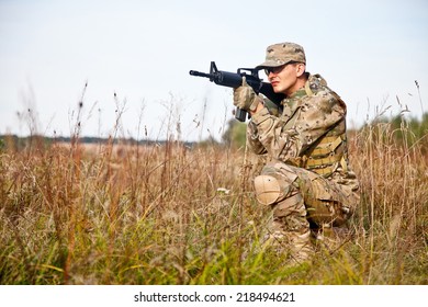 Soldier with a rifle in the field - Shutterstock ID 218494621