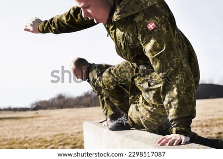 Soldier in training, military men and jump over a wall in obstacle course for fitness and endurance. Army team in camouflage uniform outdoor, train for war and exercise with mission and action