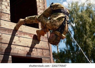 Soldier Training Rappel With Rope. Military Man Does Hanging On Climbing Equipment