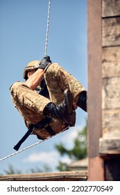 Soldier Training Rappel With Rope. Military Man Does Hanging On Climbing Equipment