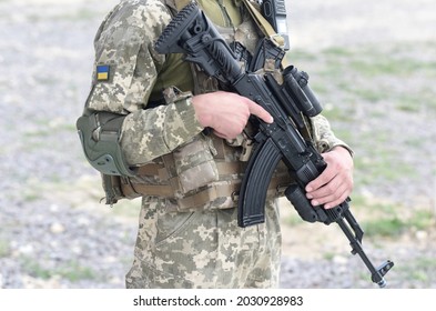 Soldier of Ukraine with assault rifle and flag of Ukraine on military uniform. Ukrainian soldier with assault rifle AK.