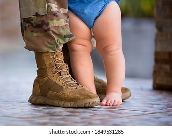 Soldier in uniform and baby at his feet - Powered by Shutterstock
