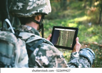 Soldier using map on tablet for orientation at forest - Powered by Shutterstock