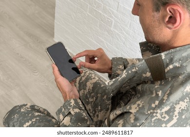 Soldier using a mobile phone against white background - Powered by Shutterstock