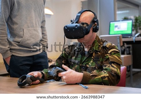 Soldier using virtual reality headset and controllers for military training simulation indoors