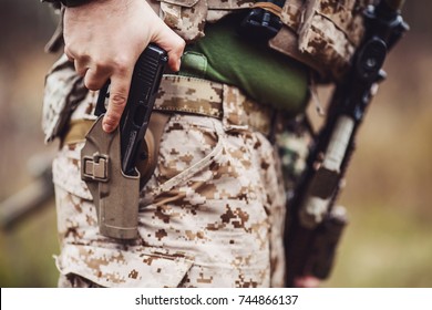 Soldier wearing uniform with gun in hand,keep gun in the holster. military concept