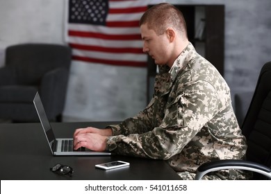 Soldier working with laptop in headquarters building - Powered by Shutterstock