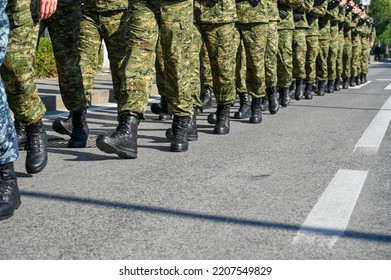 Soldiers In Camouflage Uniform And Black Boots Marching In Formation On Parade. Special Armed Forces. Army.