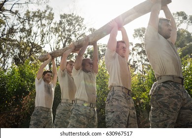 Soldiers carrying a tree log in boot camp - Powered by Shutterstock