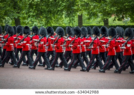 Soldiers in classic red coats march along The Mall in London, England in a grand Trooping the Colour spectacle of the Queen's Royal Guard