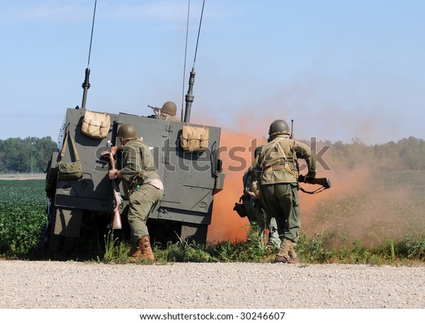 Soldiers\
engaged in gun battle behind armored\
vehicle