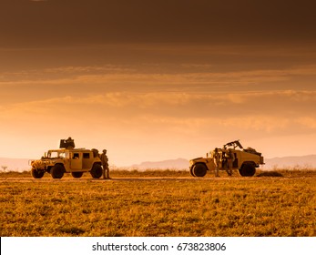 Soldiers marines patrolling on foot and escorted by a Humvee