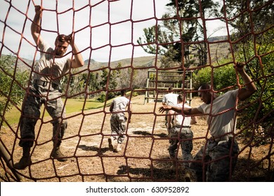 Soldiers performing training exercise on net in bootcamp - Powered by Shutterstock