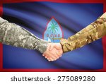 Soldiers shaking hands with flag on background - Guam