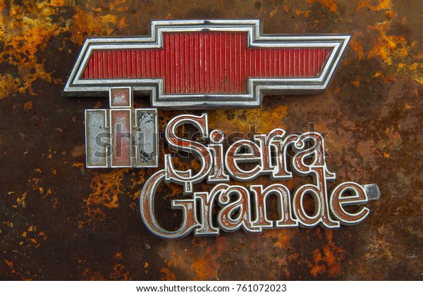 Soldotna, USA - JULY 15, 2016  vintage car\
emblems and car type logos on a rusty background: a chevrolet logo\
and sierra grande car type log can be\
seen