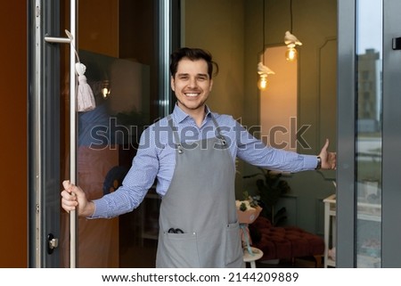 sole proprietor Glad to greet customers at the entrance to his store or cafe with a smile on his face, the concept of work after the pandemic