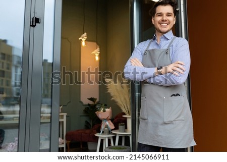 sole proprietor man glad to greet customers next to the door his shop