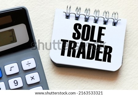 SOLE TRADER the word in a small office notebook.