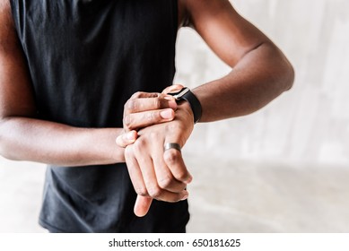 Solemn Muscular Sportsman Looking At Sport Watch