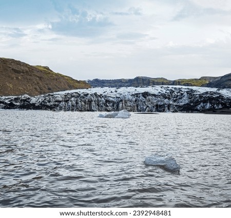 Solheimajokull picturesque glacier in southern Iceland. The tongue of this glacier slides from the volcano Katla. Beautiful glacial lake lagoon with blocks of ice and surrounding mountains.