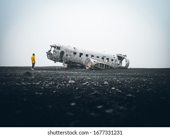 Solheimasandur Plane Wreck in Iceland with person wearing yellow jacket.