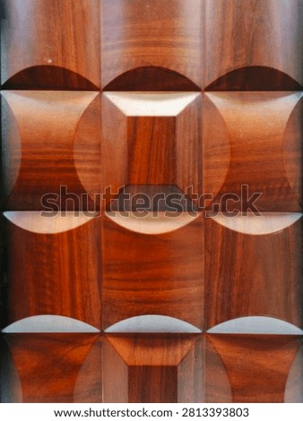 Solid 3d teak wood wall panel with repetitive concave convex square geometric carving shiny wood grain texture.