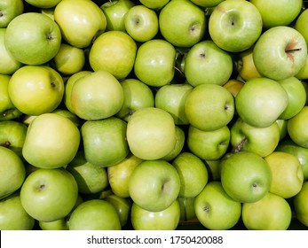 Solid background of green apples in a crate. Many organic Granny Smith apples. Healthy and affordable fruits in the supermarket, source of vitamin C. Pattern for design. View from above.