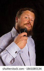 Solid Beared Man Shaving By Electric Razor Studio Portrair On Black Background.